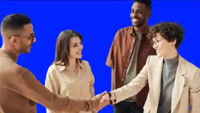 Two men and two women, one of the women shaking hands with one of the men