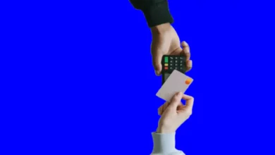 One hand holds a credit card and the other holds a cash register.